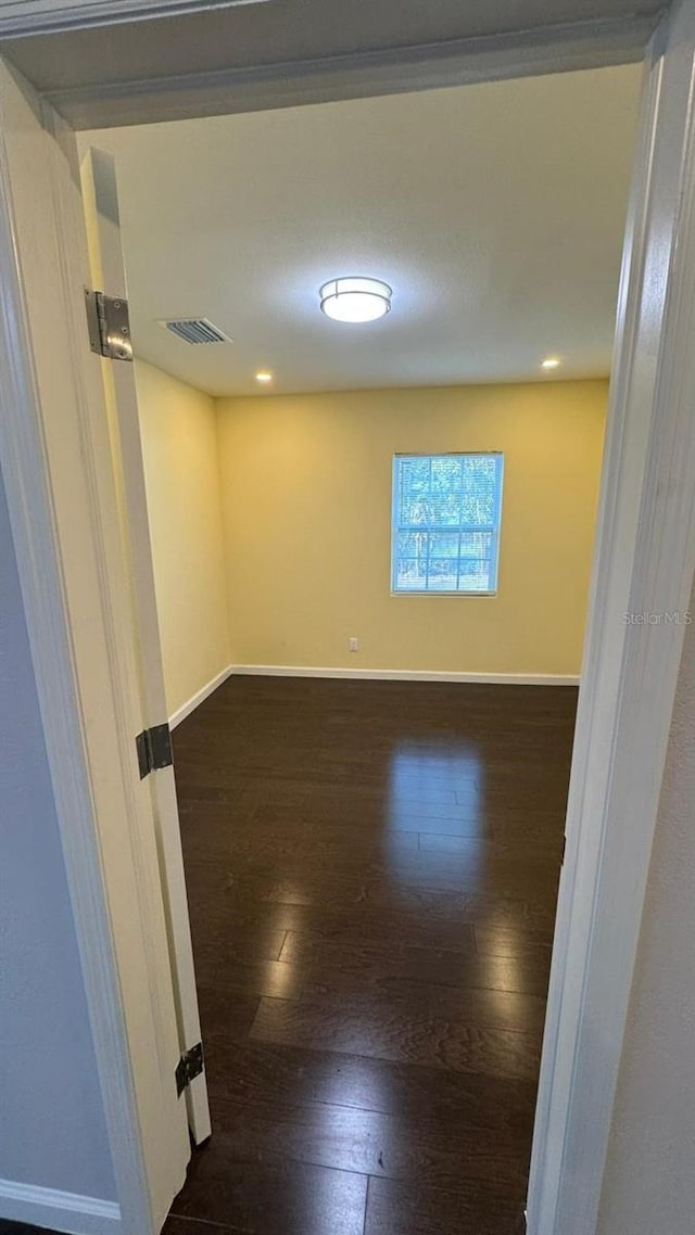 spare room with dark wood-type flooring