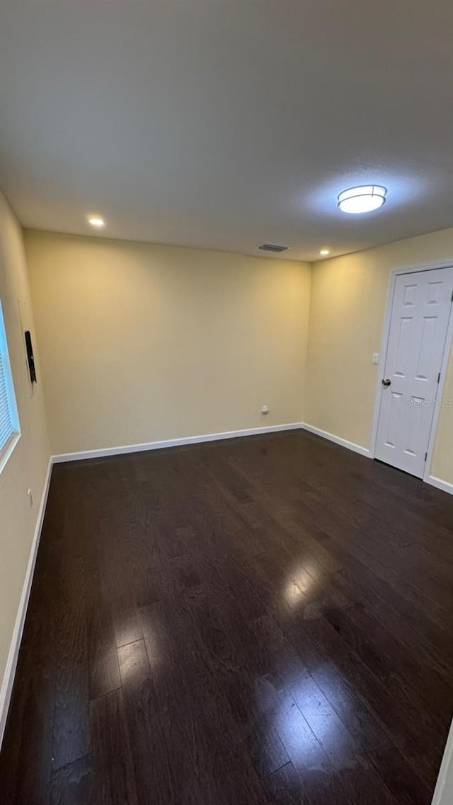 basement with dark hardwood / wood-style floors