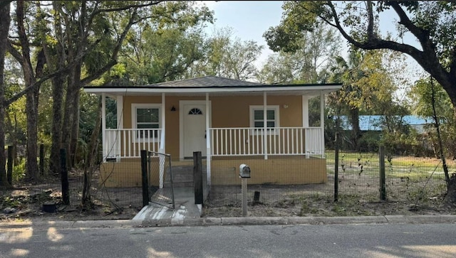 1517 S Campbell St, Perry, FL 32348 - bungalow-style home featuring a porch, a fenced front yard, a gate, and stucco siding