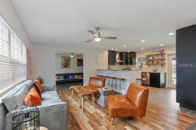 living room with light wood-type flooring, ceiling fan, and a healthy amount of sunlight