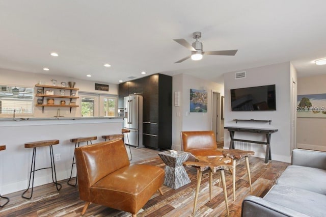 living room with ceiling fan and light hardwood / wood-style flooring