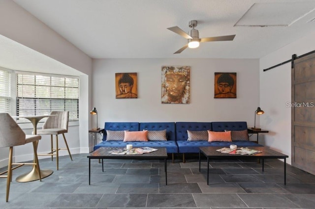 living room featuring a barn door and ceiling fan