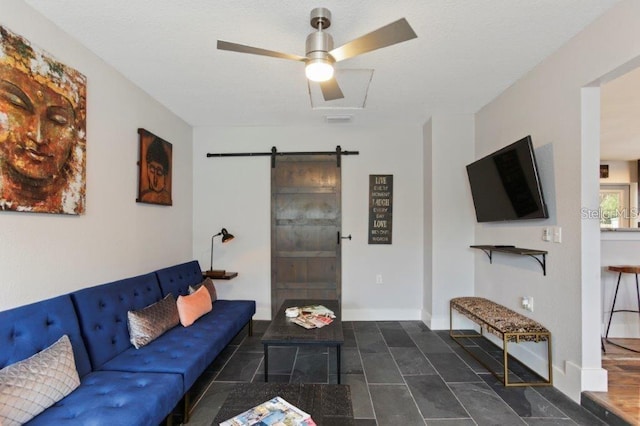 living room featuring a barn door and ceiling fan