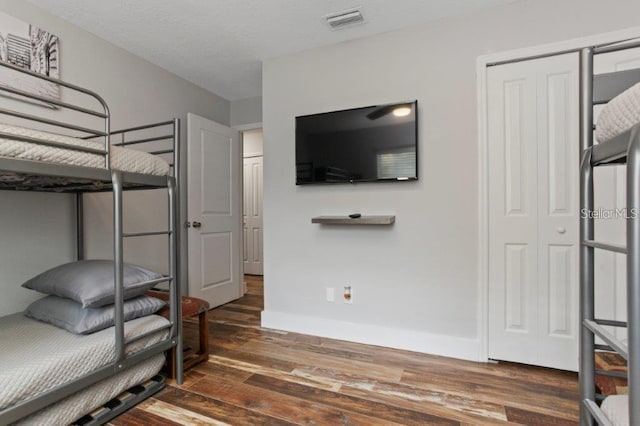 bedroom with dark wood-type flooring