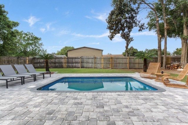 view of pool with a patio area and a yard