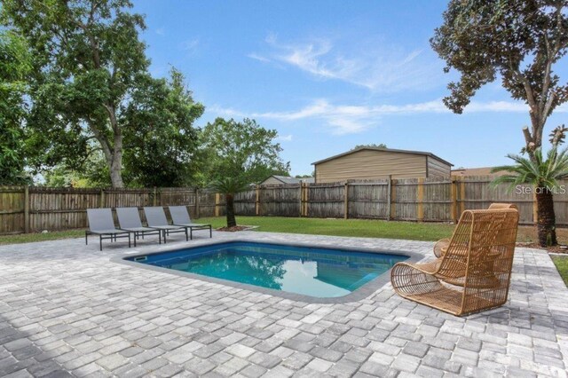 view of swimming pool featuring a yard and a patio area