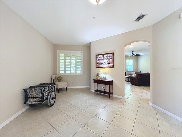 sitting room featuring a wealth of natural light, ceiling fan, and light tile patterned floors