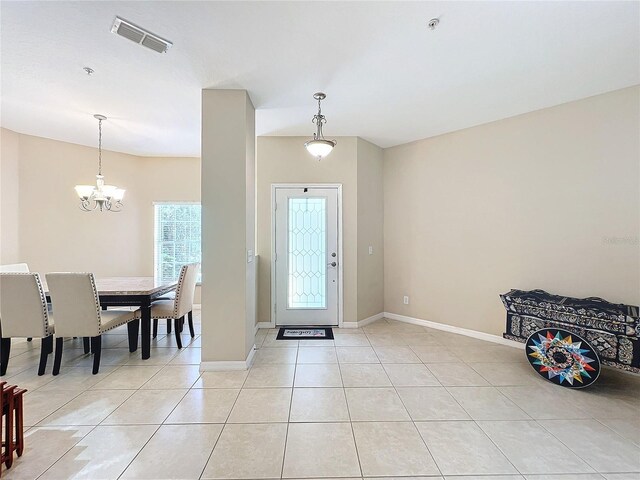 tiled entrance foyer with a notable chandelier