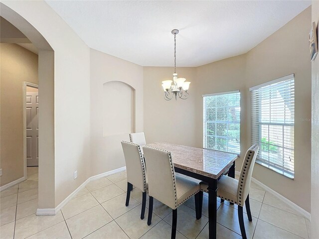 tiled dining area featuring a chandelier