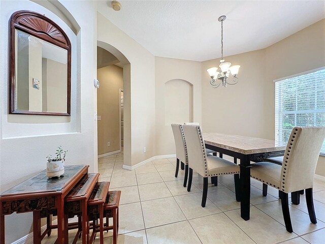 tiled dining space featuring a chandelier