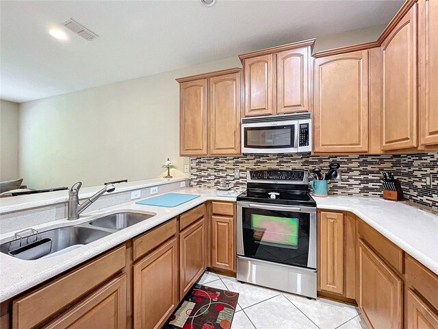 kitchen featuring light tile patterned floors, appliances with stainless steel finishes, sink, and tasteful backsplash