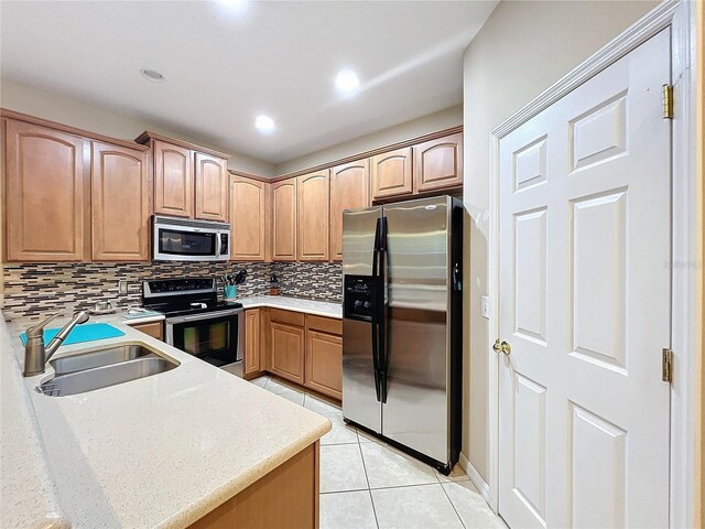 kitchen with light tile patterned flooring, stainless steel appliances, sink, and decorative backsplash