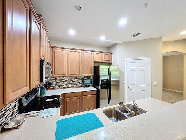 kitchen featuring appliances with stainless steel finishes, sink, and decorative backsplash