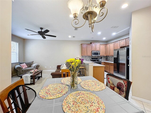 dining area featuring ceiling fan with notable chandelier and light tile patterned flooring