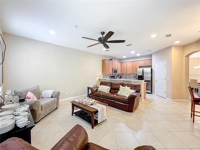 living room with ceiling fan with notable chandelier and light tile patterned floors