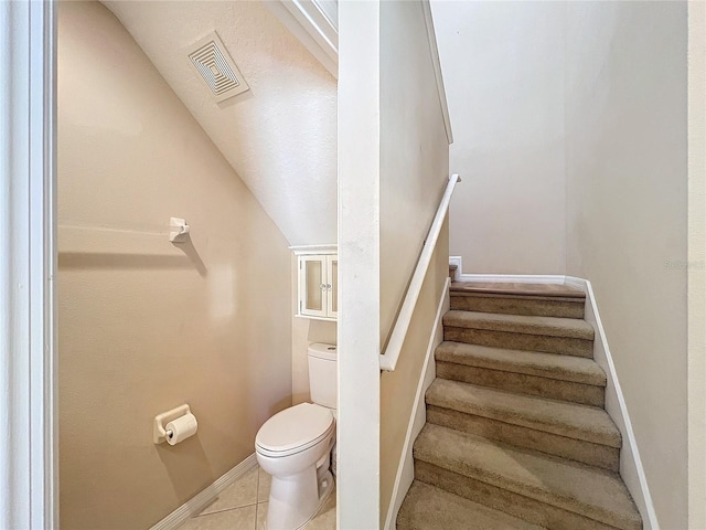 stairway with tile patterned floors