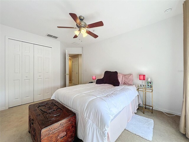 carpeted bedroom with ceiling fan and a closet