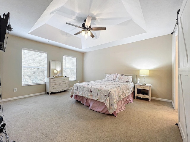 bedroom with carpet, ceiling fan, and a raised ceiling