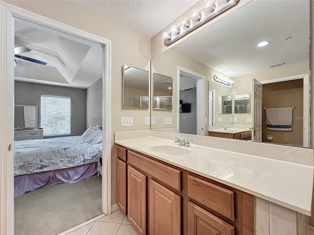 bathroom with ceiling fan, vanity, a textured ceiling, and tile patterned floors