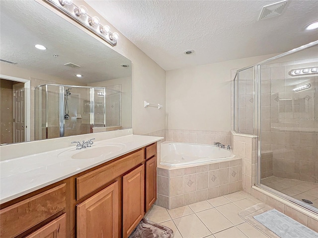 bathroom with a textured ceiling, shower with separate bathtub, tile patterned flooring, and vanity