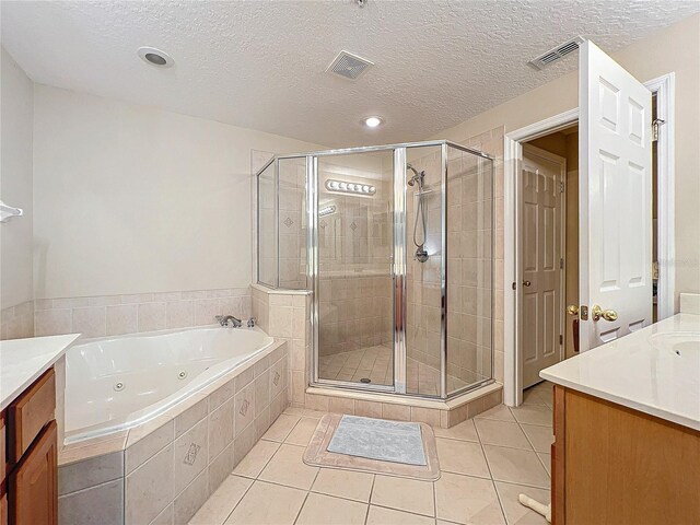 bathroom featuring a textured ceiling, vanity, plus walk in shower, and tile patterned floors