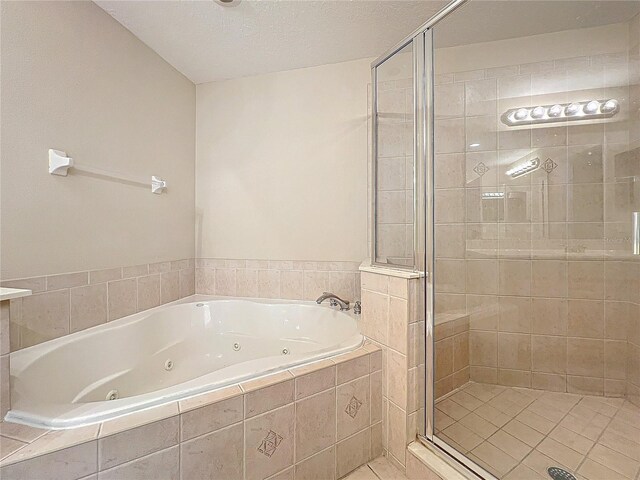 bathroom with shower with separate bathtub and a textured ceiling