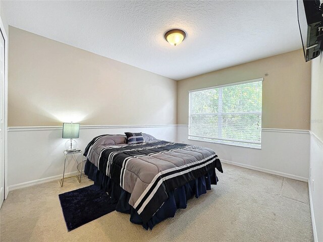 carpeted bedroom featuring a textured ceiling