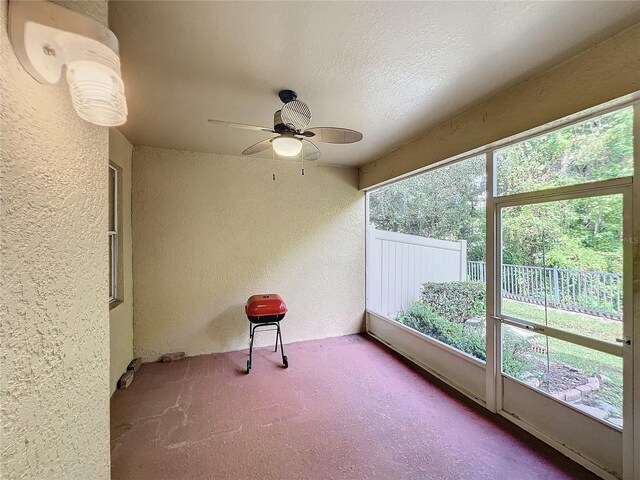 unfurnished sunroom with ceiling fan