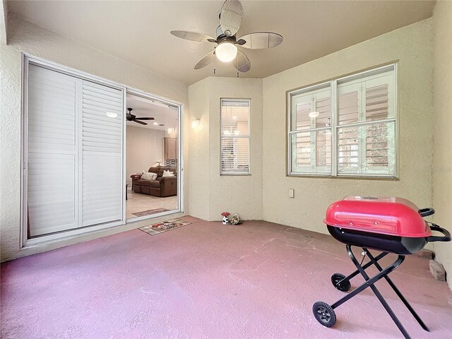 exercise room with carpet flooring, ceiling fan, and a healthy amount of sunlight