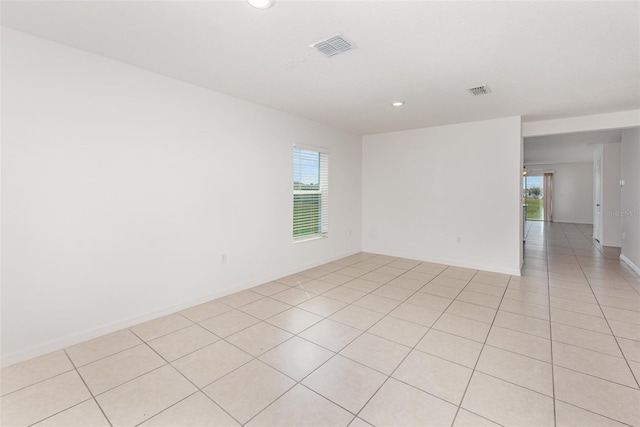 tiled spare room with a healthy amount of sunlight