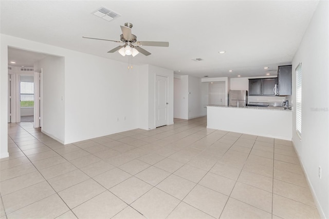 unfurnished living room featuring ceiling fan and light tile patterned flooring