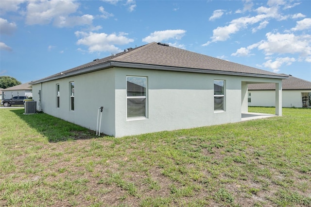 view of side of property with cooling unit, a lawn, and a patio area