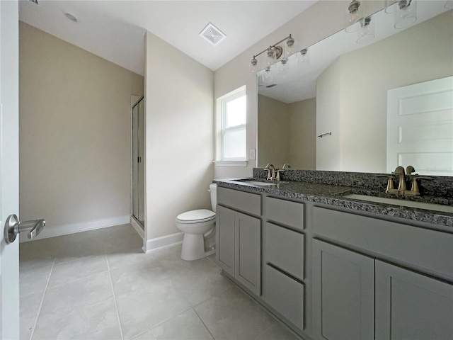 bathroom featuring vanity, toilet, tile patterned floors, and a shower with shower door