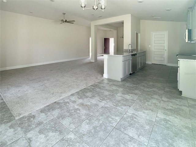 kitchen with light colored carpet, ceiling fan with notable chandelier, a sink, open floor plan, and dishwasher