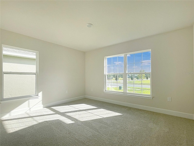 carpeted empty room featuring baseboards