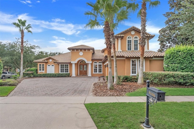 mediterranean / spanish-style home with a front lawn