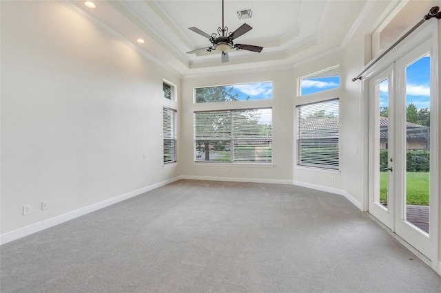 unfurnished sunroom featuring ceiling fan and a raised ceiling