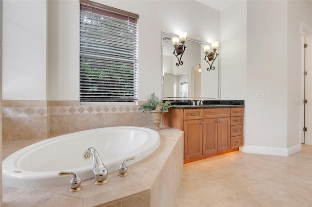 bathroom featuring tiled tub, vanity, and tile patterned flooring