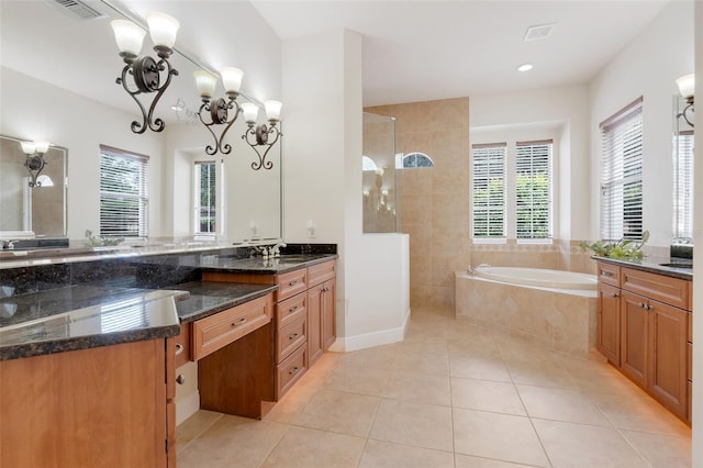 bathroom featuring independent shower and bath, a healthy amount of sunlight, vanity, and an inviting chandelier