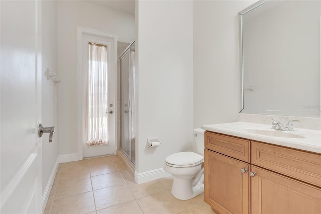 bathroom with tile patterned floors, a shower with shower door, vanity, and toilet