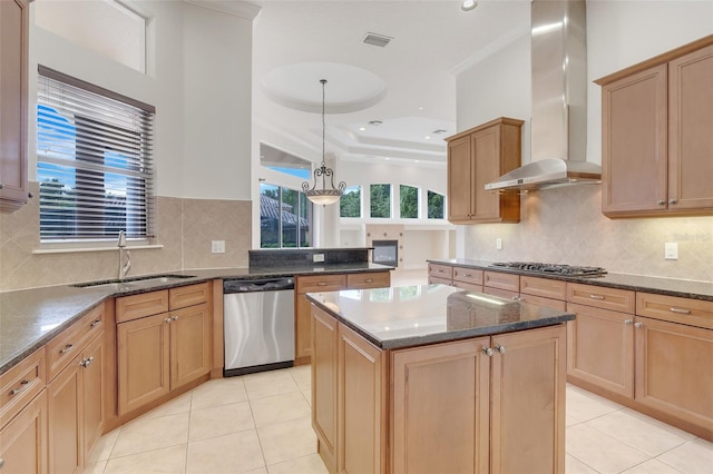 kitchen with hanging light fixtures, sink, a kitchen island, wall chimney exhaust hood, and stainless steel appliances