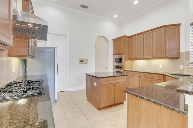 kitchen featuring dark stone counters, sink, a kitchen island, stainless steel appliances, and light tile patterned floors