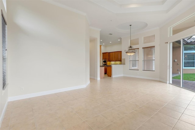 unfurnished living room with crown molding, a tray ceiling, and light tile patterned floors