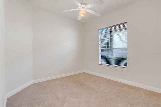 carpeted spare room featuring ceiling fan