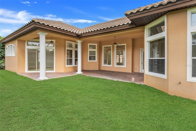 rear view of property with a patio, ceiling fan, and a yard