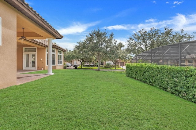 view of yard with a lanai and ceiling fan