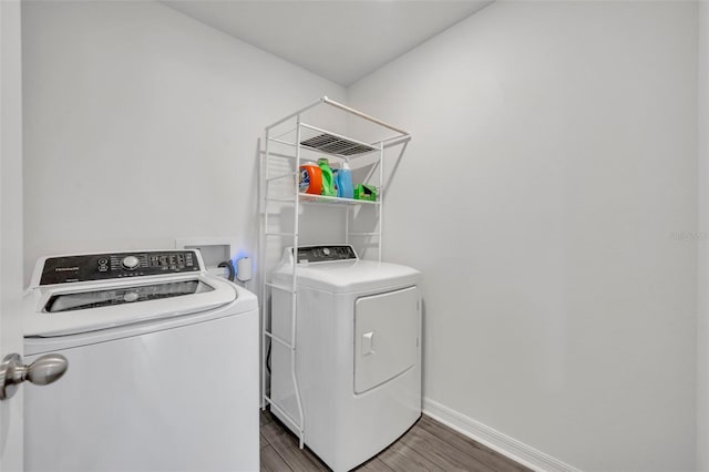 laundry area with dark hardwood / wood-style floors and washer and dryer