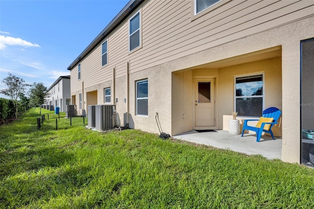 rear view of house featuring a patio, a yard, and central air condition unit