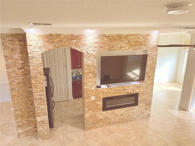 living room with light tile patterned floors, a textured ceiling, and ornamental molding