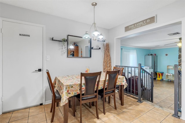 dining space with tile patterned floors, visible vents, and ceiling fan with notable chandelier